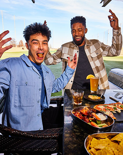 Guests enjoying food and beverages overlooking the Topgolf outfield